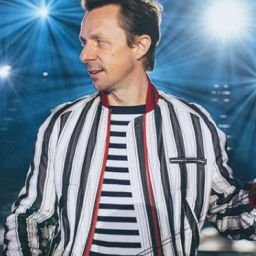 Martin Solveig DJ set, smiling in a striped jacket with headphones in hand, celebrating his 50th birthday with the free single "Fifty"
