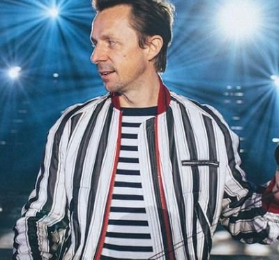 Martin Solveig DJ set, smiling in a striped jacket with headphones in hand, celebrating his 50th birthday with the free single "Fifty"